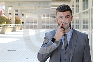 Businessman picking his nose in office space