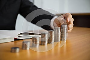 Businessman picks coins on the table, counts money . Business concept