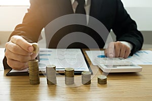 Businessman picks coins on the table, counts money . Business concept