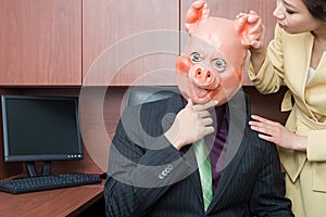 Businessman in pig mask and businesswoman