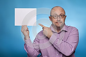 A businessman in a piked shirt holds a blank, white sign, placeholder