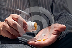 Businessman with a pill, hands close view - concept of difficulties, depression, problems, health and stress, risk of modern