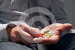 Businessman with a pill, hands close view - concept of difficulties, depression, problems, health and stress, risk of modern