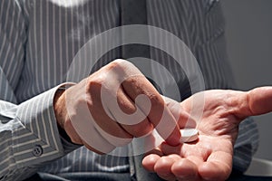 Businessman with a pill, hands close view - concept of difficulties, depression, problems, health and stress, risk of modern