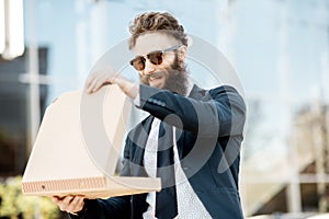 Businessman with pizza outdoors