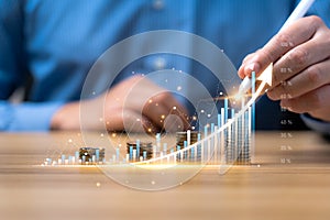 Businessman planning his business growth and goals on his desk with virtual holographic chart graph