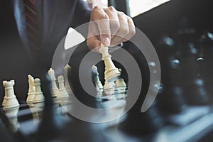 Businessman playing chess on board in office, strategy and competition concept