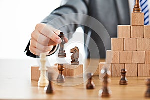 Businessman playing with chess figures and domino - the concept of success and growth