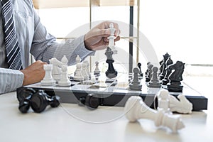 Businessman playing chess and thinking strategy about crash overthrow the opposite team and development analysis for win and