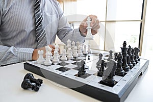 Businessman playing chess and thinking strategy about crash overthrow the opposite team and development analysis for win and