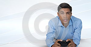 Businessman playing with computer game controller with bright background