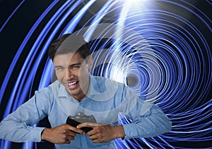 Businessman playing with computer game controller with bright tunnel background