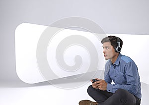 Businessman playing with computer game controller with bright white background