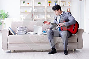 The businessman playing guitar at home