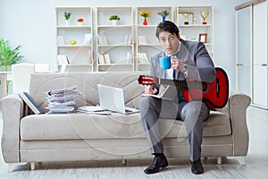 The businessman playing guitar at home