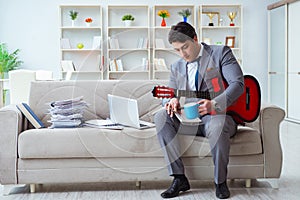 The businessman playing guitar at home