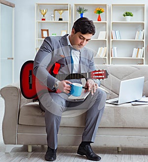 Businessman playing guitar at home