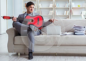 Businessman playing guitar at home