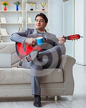 Businessman playing guitar at home