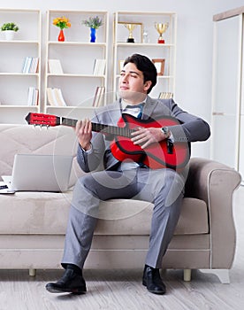 Businessman playing guitar at home