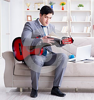 Businessman playing guitar at home