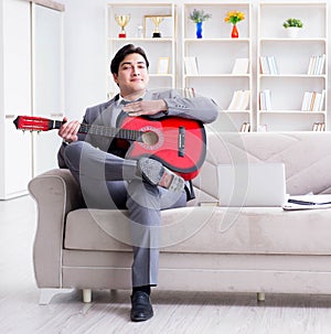 Businessman playing guitar at home