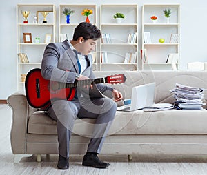 Businessman playing guitar at home