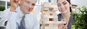 Businessman plays in a strategy of jenga hand
