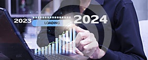 Businessman point loading progress bar changing year 2023 to 2024 and plan growing business