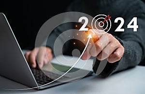 Businessman pointing at dart board icon Represents the goal setting for 2024, concept of startup, financial planning, development