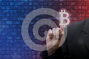 Businessman pointing digital bitcoin icon on neon blurred background. Rise and fall of bitcoin prices. Virtual cryptocurrency