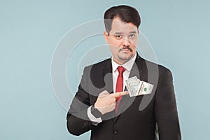 Businessman pointing finger at money in the pocket of a bribe