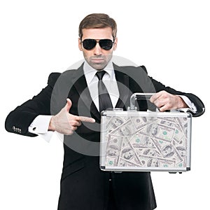 Businessman pointing his finger towards metal suitcase