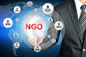 Businessman pointing on NGO (Non-Governmental Organization) sign on virtual screen photo