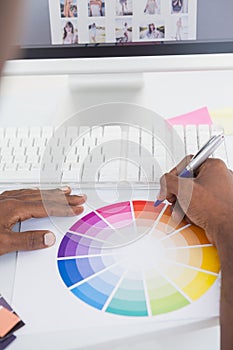 Businessman pointing with a pen on colour wheel