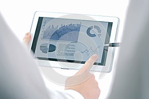 Businessman pointing with pen on a digital tablet screen.