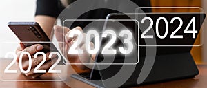 Businessman pointing to digital 2024 on virtual screen. Countdown to 2024 concept. Space for text. New Year's Eve