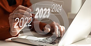 Businessman pointing to digital 2024 on virtual screen. Countdown to 2024 concept. Space for text. New Year's Eve