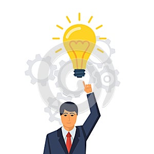 Businessman points to a big light bulb as a symbol big idea.