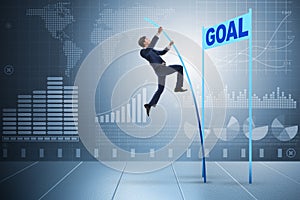 The businessman pole vaulting towards his goal in business concept