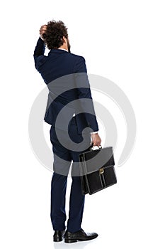 Businessman pondering something and holding a briefcase