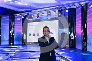 Businessman portrait on conference meeting, presenter joining a seminar via video conference call in empty convention