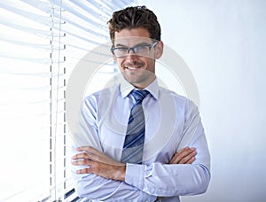 Businessman, portrait and smile with arms crossed in office for professional career in finance, confidence or pride