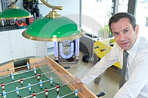 Businessman posing near fusball photo