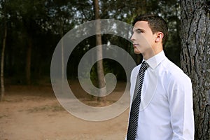 Businessman posing relaxed on a park forest