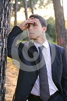 Businessman posing relaxed on a park forest