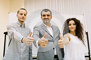 Businessman posing with staff members on the office background. Corporate business concept.