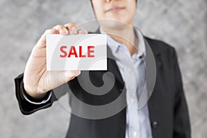 businessman presenting business card with word sale