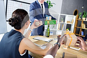 Businessman presenting gifts to colleagues