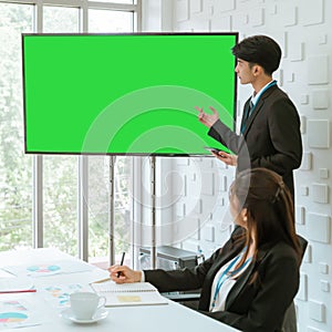 Businessman presenting work and flowchart on blank television monitor mock up screen in a conference room